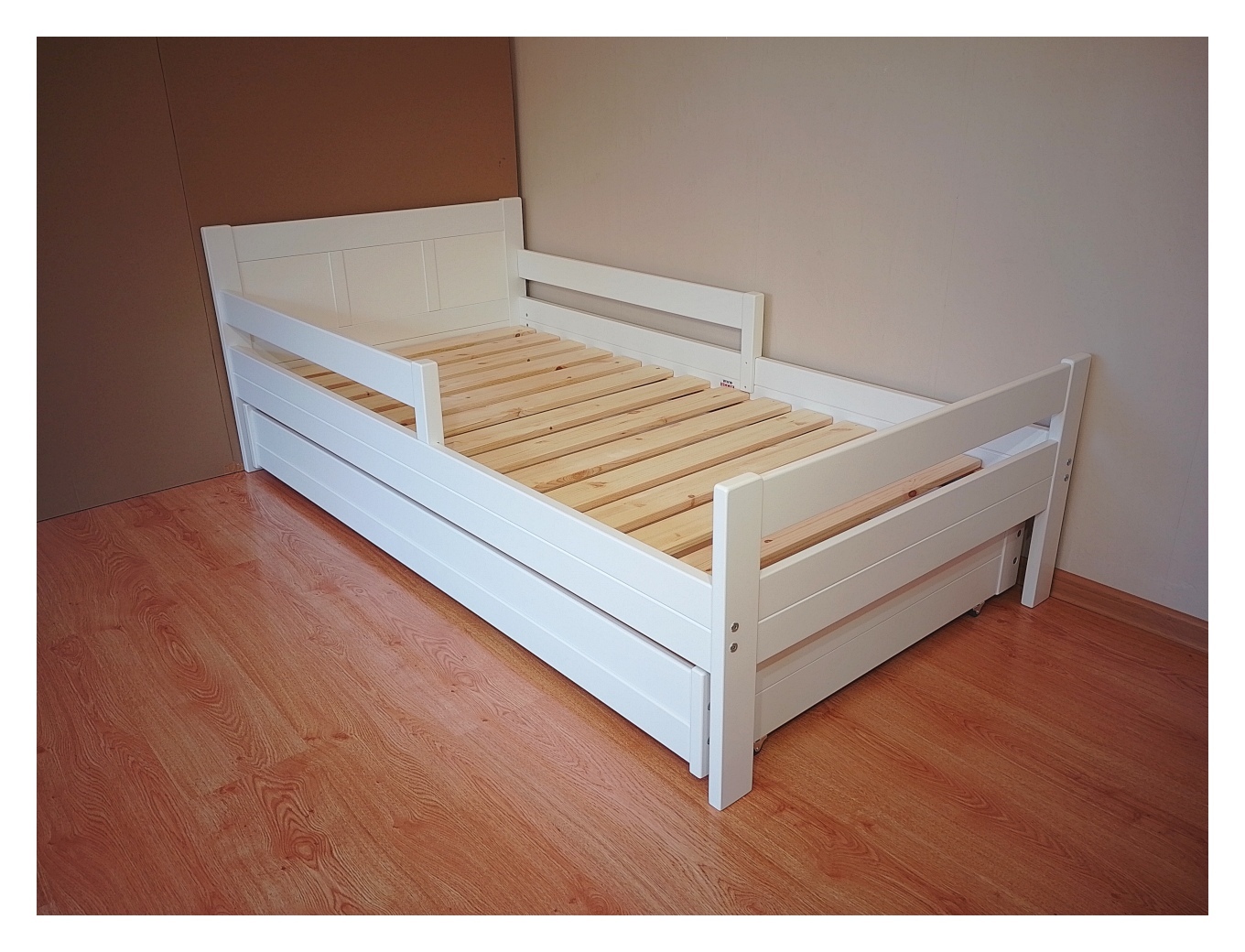 Lastevoodi tugevast kasepuidust ja hea kandevõimega madratsile mõõdus 90x180 cm pesukastiga valge voodi.