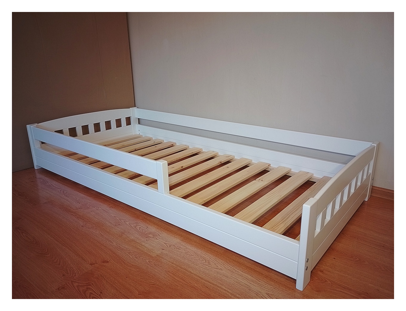 Madal voodi 90×200 turvapiiretega. Valge