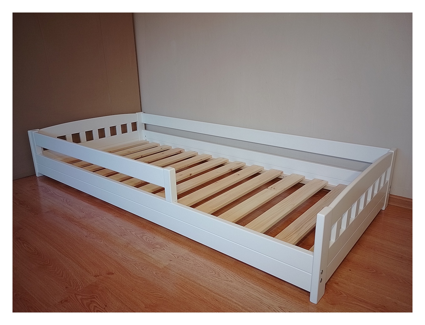 Madal voodi 90×200 turvapiiretega. Valge